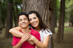 Parenting Teens - Hispanic mother and son smiling with arms around each other