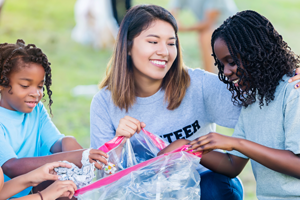 Teenage problems - Three young girls helping throw away trash gathered from a park