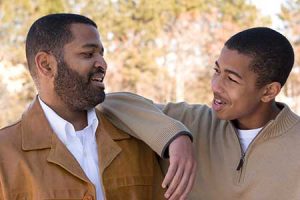 Father and son smiling at each other while talking