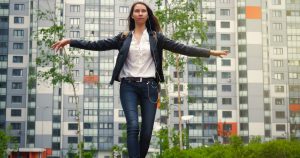 Female teenager walking on a balance beam in a park