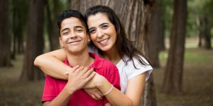 Hispanic Mom and her son with arms around each other